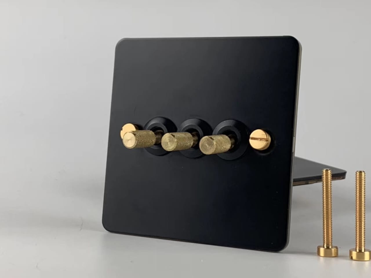 Detailed Black & Brass Toggle Light Switch - 3 levers