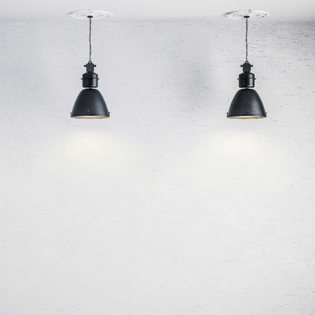 Two black pendant lights against a light grey wall
